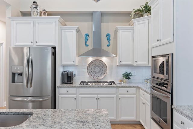 2300 Lark Sparrow St, Myrtle Beach, SC 29577 - kitchen featuring stainless steel appliances, wall chimney exhaust hood, white cabinetry, decorative backsplash, and light stone countertops