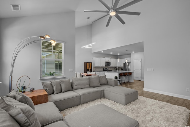 1168 Baker Creek Loop, Myrtle Beach, SC 29579 - living room with high vaulted ceiling, ceiling fan, light wood-style floors, and baseboards