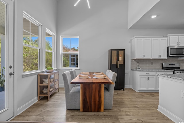 1168 Baker Creek Loop, Myrtle Beach, SC 29579 - kitchen with stainless steel appliances, white cabinets, baseboards, decorative backsplash, and light wood finished floors
