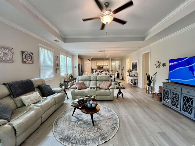 200 Ponte Vedra Dr, Murrells Inlet, SC 29576 - living area featuring light wood-style floors, a ceiling fan, a chandelier, a raised ceiling, and crown molding