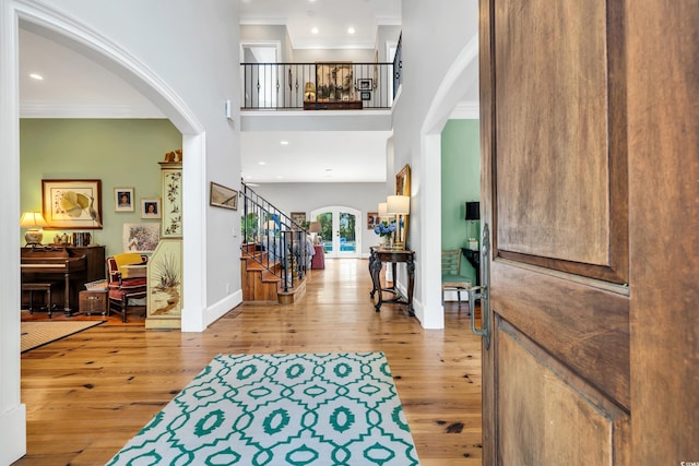 2382 Waverly Rd, Pawleys Island, SC 29585 - foyer featuring arched walkways, stairs, wood-type flooring, crown molding, and baseboards