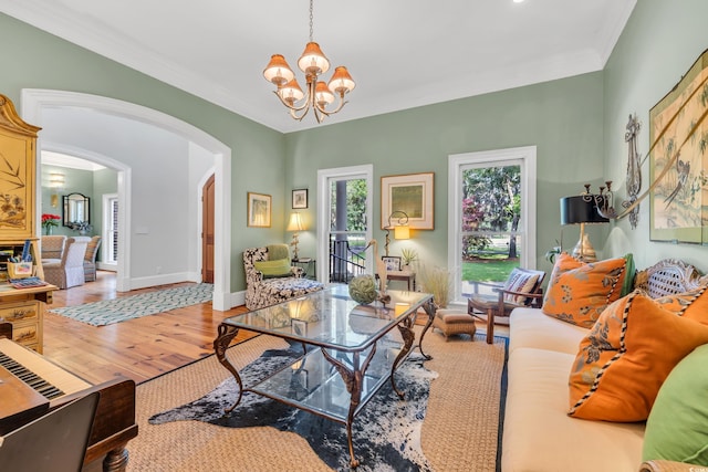 2382 Waverly Rd, Pawleys Island, SC 29585 - living room with arched walkways, a chandelier, wood finished floors, ornamental molding, and baseboards