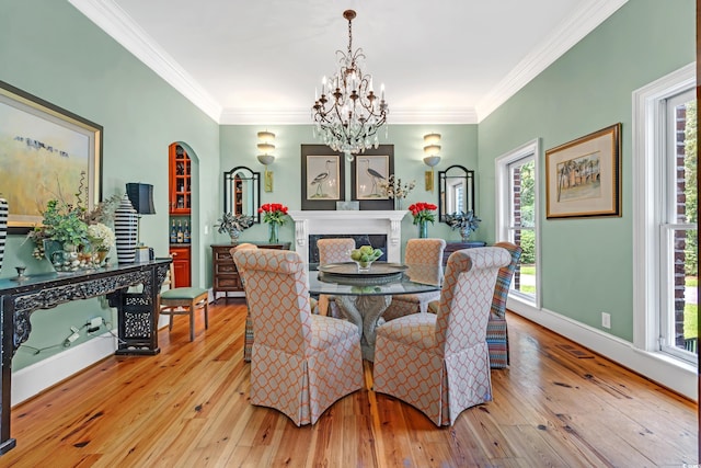 2382 Waverly Rd, Pawleys Island, SC 29585 - dining room featuring hardwood / wood-style floors, a chandelier, ornamental molding, baseboards, and arched walkways