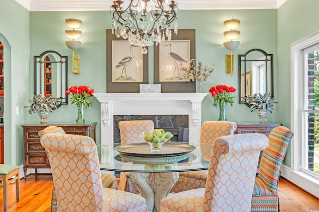 2382 Waverly Rd, Pawleys Island, SC 29585 - dining space with hardwood / wood-style floors, crown molding, plenty of natural light, a chandelier, and a premium fireplace