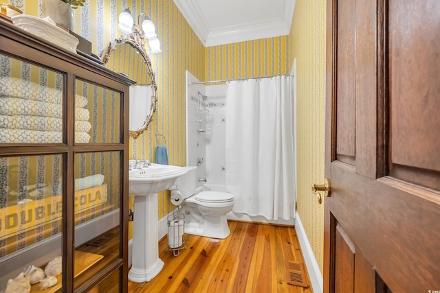 2382 Waverly Rd, Pawleys Island, SC 29585 - bathroom featuring wallpapered walls, crown molding, toilet, hardwood / wood-style flooring, and baseboards