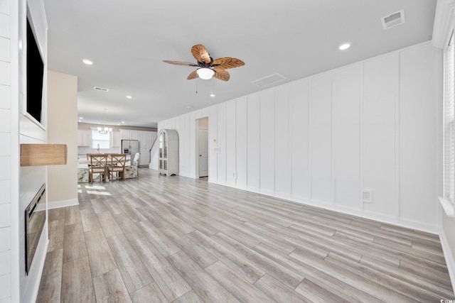 2475 Blue Crane Cir Unit 106, Myrtle Beach, SC 29577 - unfurnished living room featuring light wood-style flooring, a ceiling fan, recessed lighting, a chandelier, and a decorative wall