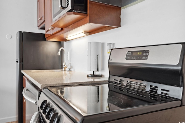 5409 N Ocean Blvd Unit 106/7 108, North Myrtle Beach, SC 29582 - kitchen with range, light stone counters, a sink, and stainless steel microwave