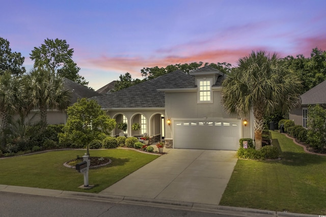 2318 Via Palma Dr, North Myrtle Beach, SC 29582 - french country inspired facade featuring concrete driveway, a yard, roof with shingles, an attached garage, and stucco siding