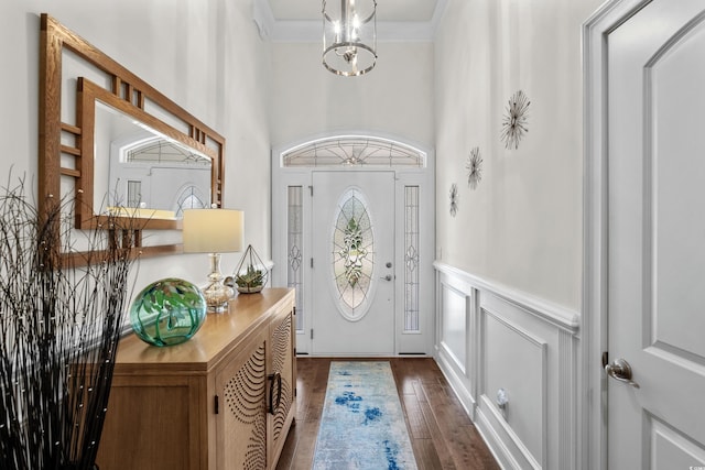 2318 Via Palma Dr, North Myrtle Beach, SC 29582 - foyer featuring a wainscoted wall, dark wood finished floors, crown molding, a high ceiling, and a decorative wall