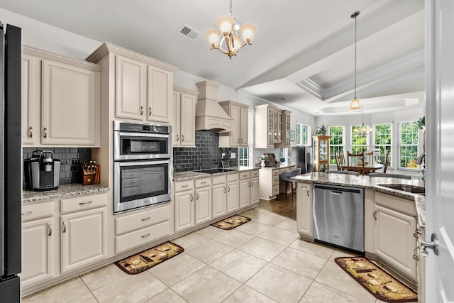 2318 Via Palma Dr, North Myrtle Beach, SC 29582 - kitchen with appliances with stainless steel finishes, a chandelier, a tray ceiling, tasteful backsplash, and a sink