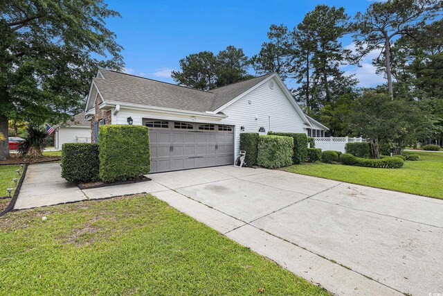 7007 Blade Beak Ln, Myrtle Beach, SC 29588 - view of side of home featuring an attached garage, concrete driveway, and a shingled roof