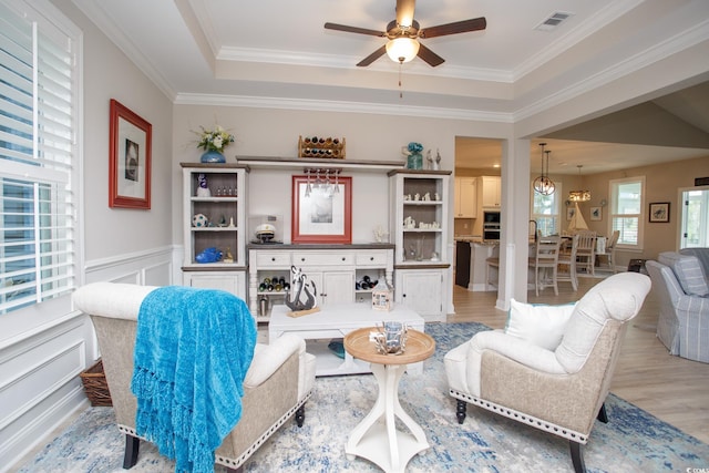 383 Mikita Dr, Surfside Beach, SC 29575 - living area featuring light wood-style floors, a ceiling fan, a decorative wall, crown molding, and wainscoting