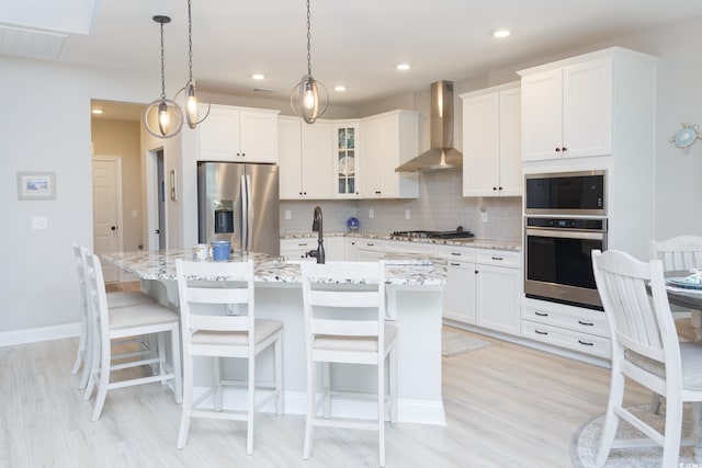 383 Mikita Dr, Surfside Beach, SC 29575 - kitchen featuring appliances with stainless steel finishes, wall chimney exhaust hood, light wood-style floors, decorative backsplash, and recessed lighting
