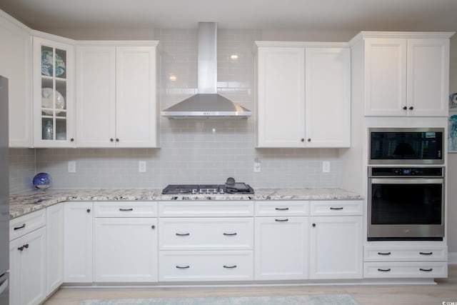 383 Mikita Dr, Surfside Beach, SC 29575 - kitchen with stainless steel appliances, wall chimney exhaust hood, white cabinets, and tasteful backsplash