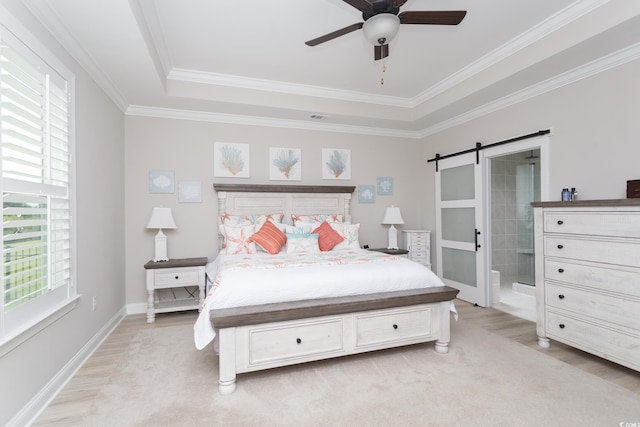 383 Mikita Dr, Surfside Beach, SC 29575 - bedroom with light wood finished floors, a barn door, a tray ceiling, ornamental molding, and connected bathroom