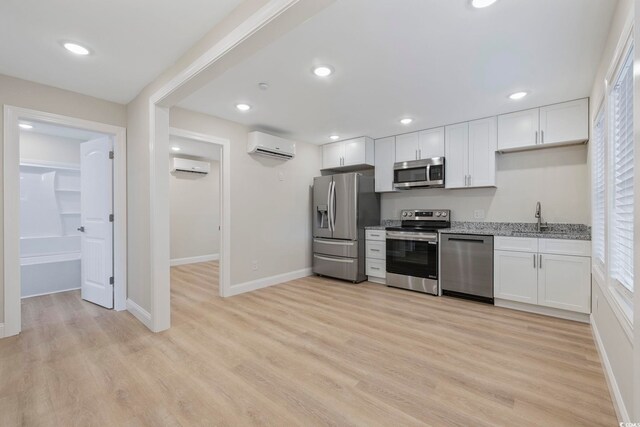 409 2nd Ave S, Myrtle Beach, SC 29577 - kitchen with stainless steel appliances, a wall unit AC, a sink, light wood finished floors, and recessed lighting
