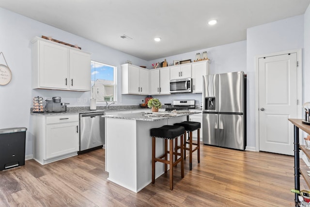 5001 Sweet Birch Ln, Conway, SC 29526 - kitchen with stainless steel appliances, light wood-style flooring, a kitchen island, white cabinets, and recessed lighting