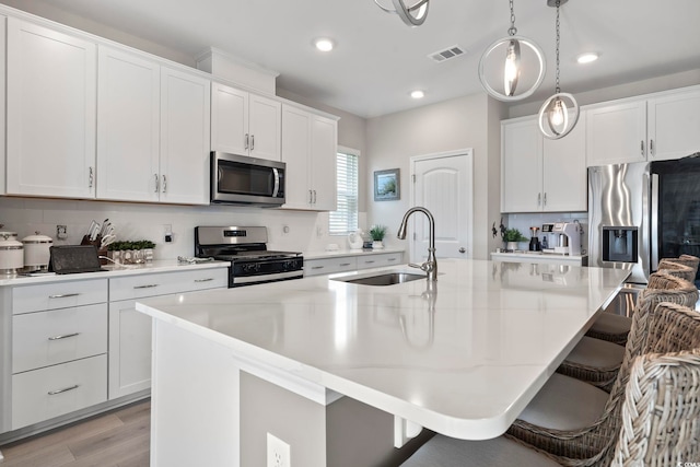 2572 Brescia St, Myrtle Beach, SC 29579 - kitchen with appliances with stainless steel finishes, a sink, a kitchen island with sink, backsplash, and recessed lighting