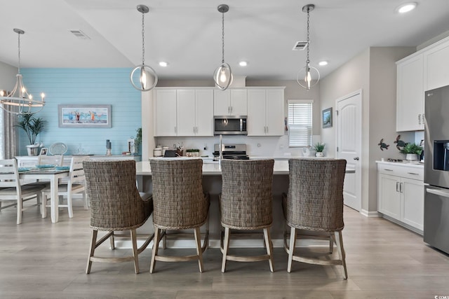 2572 Brescia St, Myrtle Beach, SC 29579 - kitchen with appliances with stainless steel finishes, recessed lighting, an island with sink, light countertops, and white cabinetry