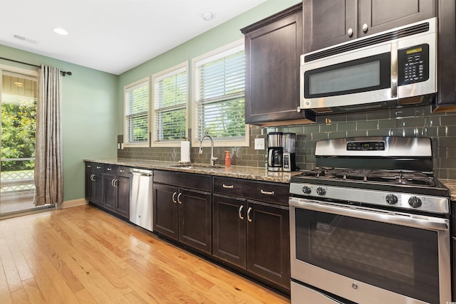 18 Cyclamen Ct, Murrells Inlet, SC 29576 - kitchen with appliances with stainless steel finishes, a sink, light stone countertops, light wood-style floors, and tasteful backsplash