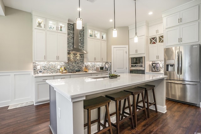 769 Country Club Dr, Pawleys Island, SC 29585 - kitchen with appliances with stainless steel finishes, wall chimney range hood, dark wood-style flooring, decorative backsplash, and light countertops