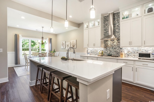 769 Country Club Dr, Pawleys Island, SC 29585 - kitchen featuring wall chimney range hood, a sink, decorative backsplash, an island with sink, and dark wood finished floors