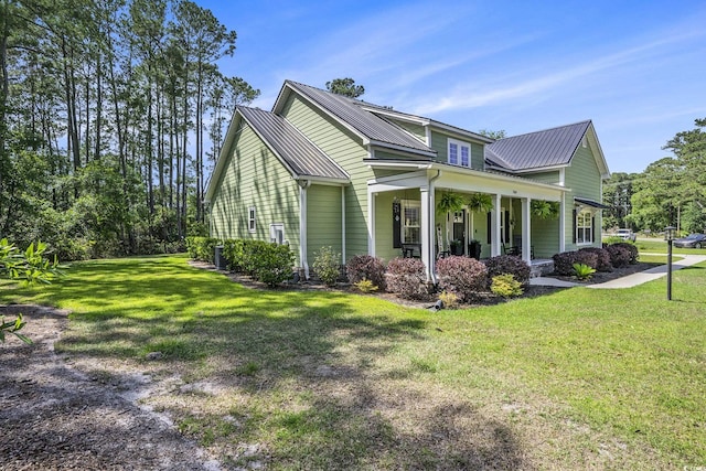 769 Country Club Dr, Pawleys Island, SC 29585 - view of side of home featuring covered porch, a lawn, and metal roof