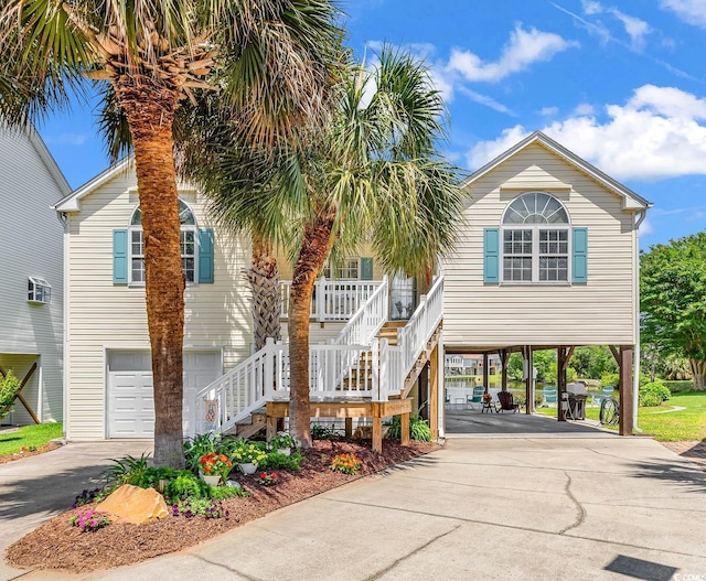 521 Bay Dr, Garden City Beach, SC 29576 - beach home with asphalt driveway, a carport, a garage, and stairway