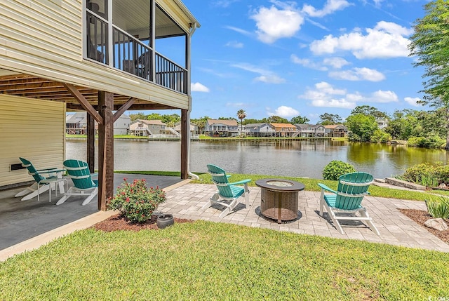 521 Bay Dr, Garden City Beach, SC 29576 - view of green lawn featuring an outdoor fire pit, a patio area, and a water view