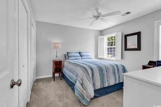 521 Bay Dr, Garden City Beach, SC 29576 - bedroom featuring light colored carpet, a closet, a textured ceiling, ceiling fan, and baseboards