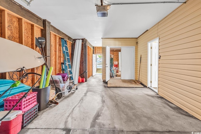 521 Bay Dr, Garden City Beach, SC 29576 - garage featuring wooden walls and a garage door opener