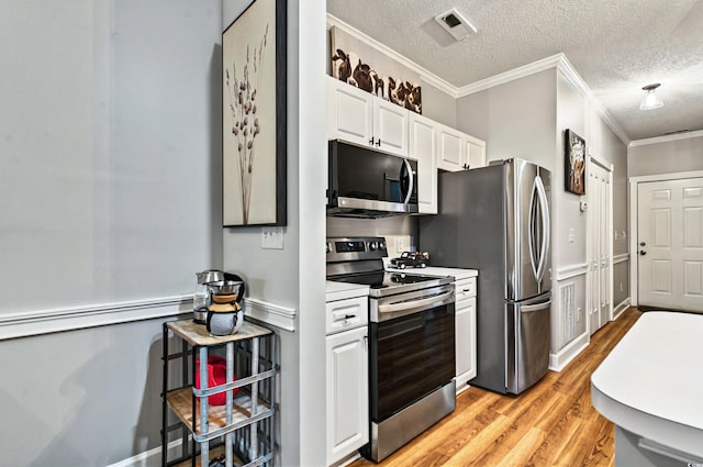4251 Hibiscus Dr Unit 202, Little River, SC 29566 - kitchen featuring stainless steel appliances, light wood-type flooring, white cabinets, a textured ceiling, and crown molding
