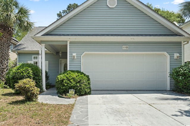 618 5th Ave S, North Myrtle Beach, SC 29582 - view of front facade featuring driveway, an attached garage, and a shingled roof