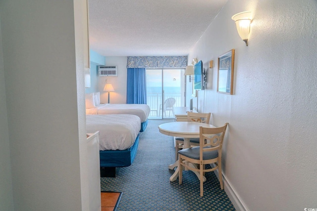 1207 Ocean Blvd S Unit 20802, Myrtle Beach, SC 29577 - bedroom with a textured wall, carpet flooring, an AC wall unit, baseboards, and a textured ceiling