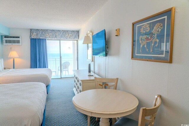 1207 Ocean Blvd S Unit 20802, Myrtle Beach, SC 29577 - carpeted bedroom featuring a textured ceiling, a wall unit AC, and access to exterior