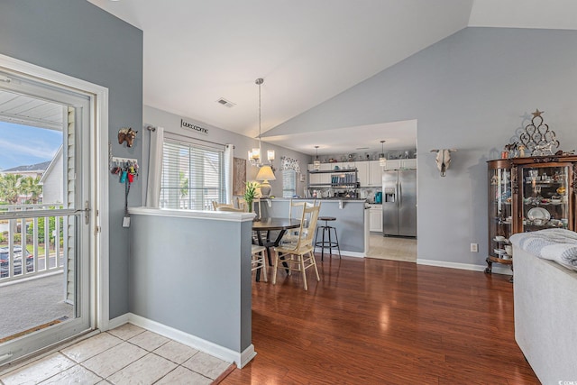 117 Butkus Dr Unit 6, Myrtle Beach, SC 29588 - kitchen with stainless steel refrigerator with ice dispenser, vaulted ceiling, white cabinetry, light wood-style flooring, and hanging light fixtures
