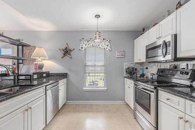 117 Butkus Dr Unit 6, Myrtle Beach, SC 29588 - kitchen with appliances with stainless steel finishes, a sink, backsplash, white cabinetry, and dark stone countertops