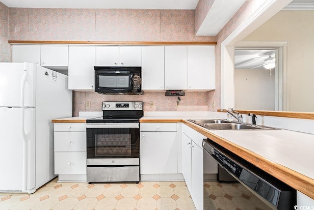 159-1 Weehawka Way Unit 159-1, Pawleys Island, SC 29585 - kitchen with black appliances, wallpapered walls, a sink, light floors, and white cabinets