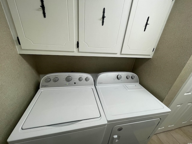 4637 Dogwood St, Loris, SC 29569 - laundry area with washing machine and clothes dryer, a textured wall, light wood-type flooring, and cabinet space