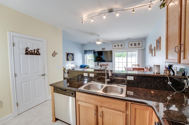 702 Beach Walk Pl Unit 702, Myrtle Beach, SC 29577 - kitchen with stainless steel dishwasher, a sink, open floor plan, a ceiling fan, and dark stone countertops