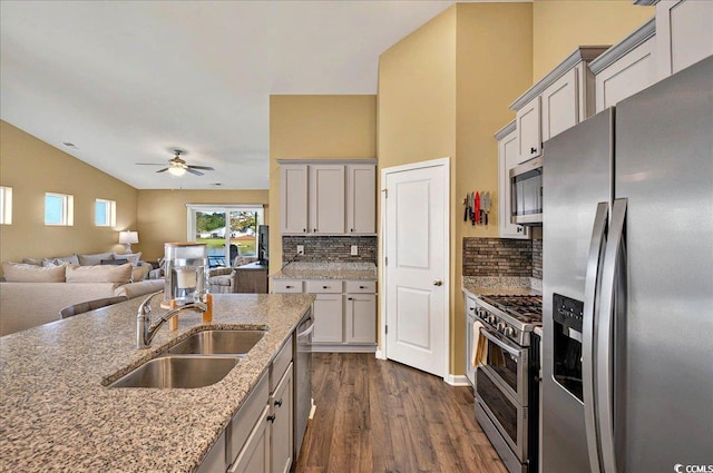1631 Hepburn Dr, Little River, SC 29566 - kitchen with appliances with stainless steel finishes, a sink, dark wood-type flooring, ceiling fan, and tasteful backsplash