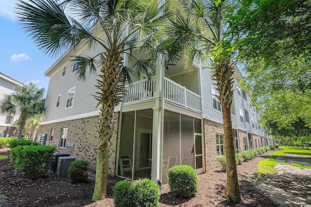 6253 Catalina Dr Unit 1523, North Myrtle Beach, SC 29582 - view of side of property featuring a balcony, brick siding, a sunroom, and central AC unit