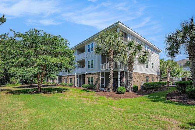 6253 Catalina Dr Unit 1523, North Myrtle Beach, SC 29582 - rear view of property with brick siding, a yard, and cooling unit