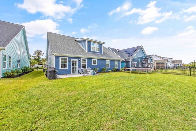 1008 Mary Read Dr, North Myrtle Beach, SC 29582 - back of property featuring a trampoline, a patio area, and a shingled roof