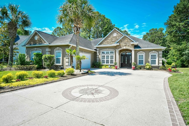 5718 Herring Gull Cir N, Myrtle Beach, SC 29582 - view of front of house featuring stucco siding, a garage, concrete driveway, and stone siding