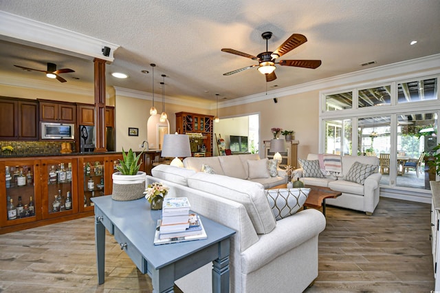5718 Herring Gull Cir N, Myrtle Beach, SC 29582 - living room with ceiling fan, a textured ceiling, light wood-style floors, ornamental molding, and recessed lighting
