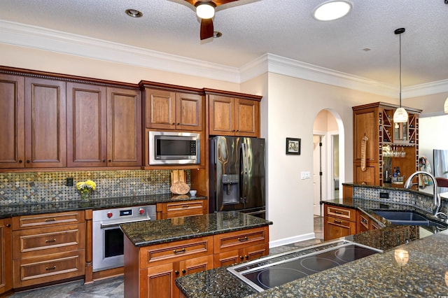 5718 Herring Gull Cir N, Myrtle Beach, SC 29582 - kitchen with appliances with stainless steel finishes, a sink, a kitchen island, arched walkways, and a ceiling fan