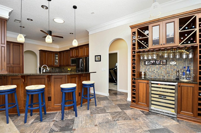 5718 Herring Gull Cir N, Myrtle Beach, SC 29582 - indoor bar featuring beverage cooler, black fridge, arched walkways, ceiling fan, and tasteful backsplash