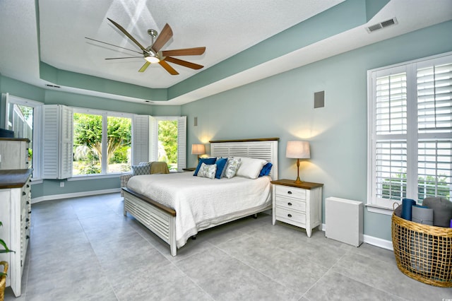 5718 Herring Gull Cir N, Myrtle Beach, SC 29582 - bedroom featuring multiple windows, baseboards, ceiling fan, and a tray ceiling