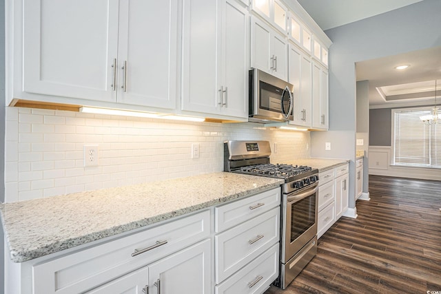 2004 Potomac Ct, Myrtle Beach, SC 29579 - kitchen with appliances with stainless steel finishes, dark wood-style floors, white cabinetry, glass insert cabinets, and light stone counters